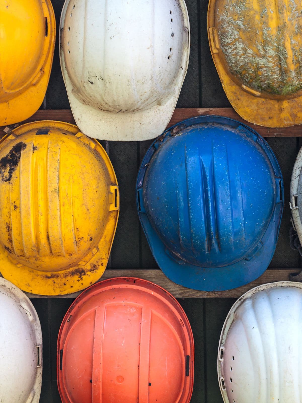 Colourful construction hard hats on a site rack